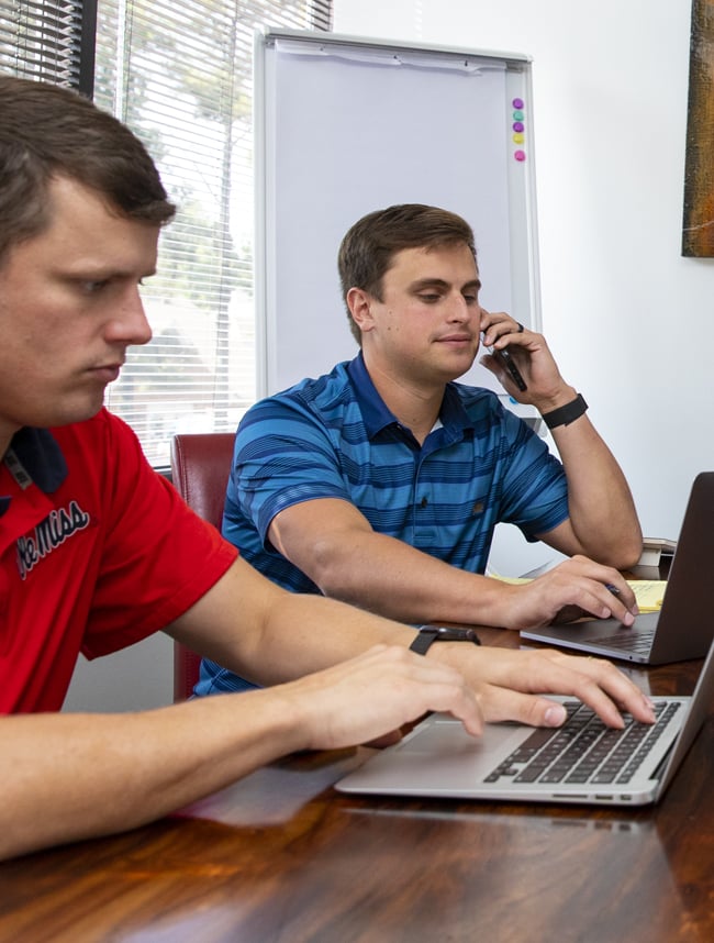 team member on phone looking at computer