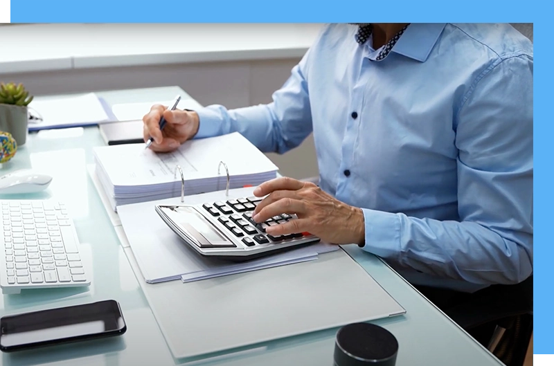 man at desk working on numbers with calculator